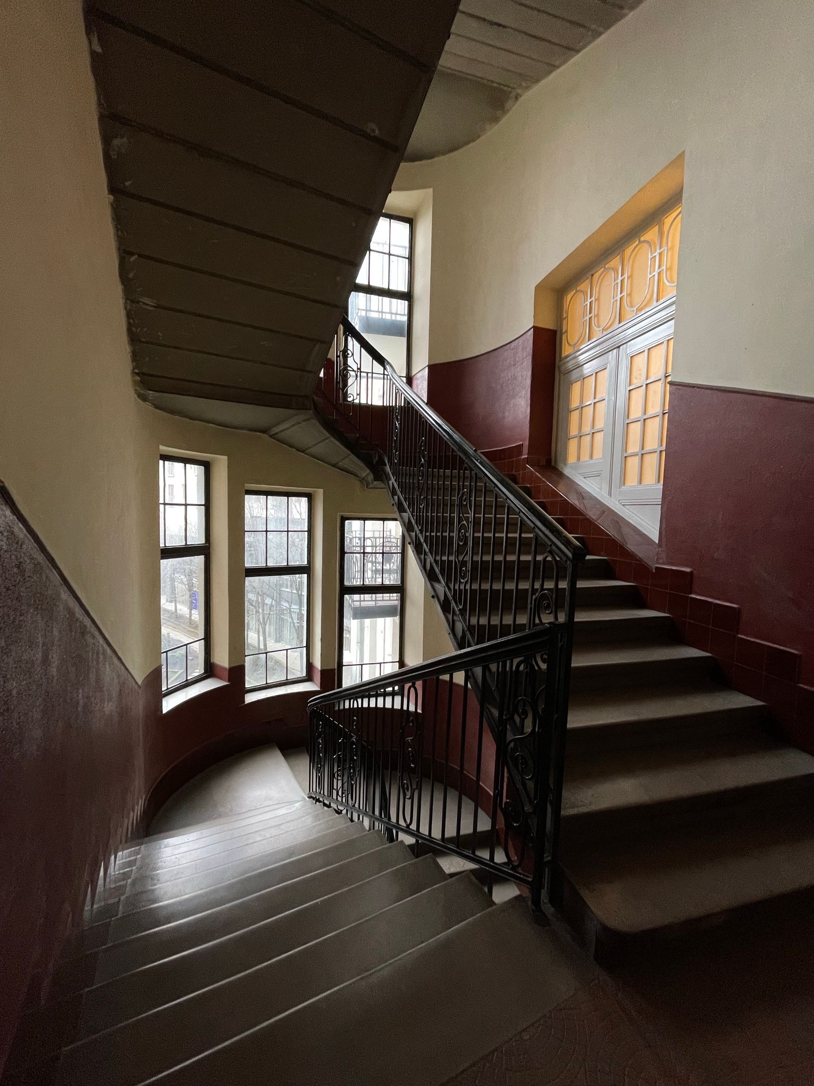 Warmes Altbau-Treppenhaus mit schmiedeeisernem Geländer